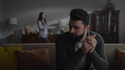 Distressed Man Reacts to Arguing Woman Indoors