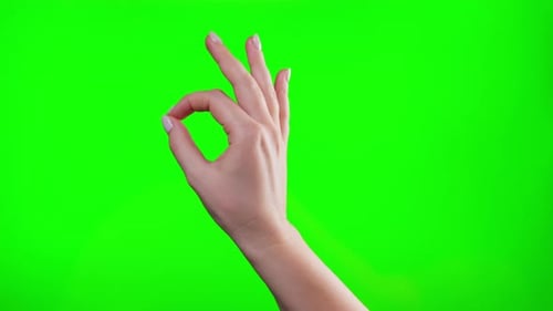 A Woman's Hand Showing the OK Gesture Symbol Approval on Green Background