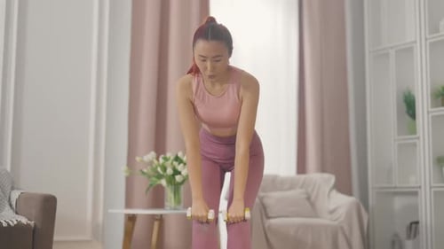 Young Woman Working Out with Dumbbells at Home