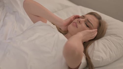 Distressed Woman Lying in Bed with Headache