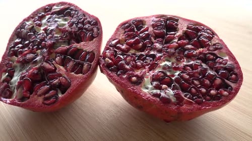 Rotating pomegranate fruit and seeds, top view, 4K