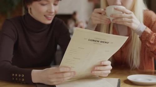 Two Girls Choosing Meal In Cafe