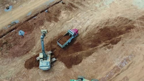 Excavator Loading Dirt into Dump Truck From Above