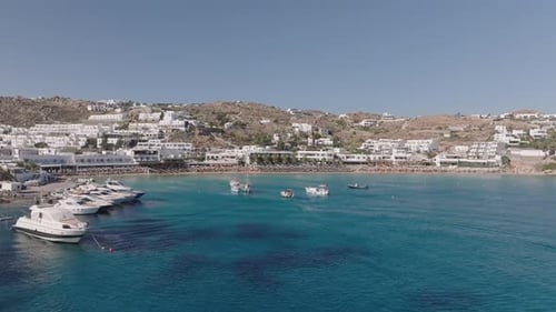 Aerial video of the coastline with hotels and yachts moored off the coast of Mykonos