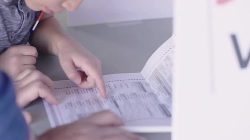 Curious Boy Discussing Ballot with Father Polling Place Voting Booth Adult