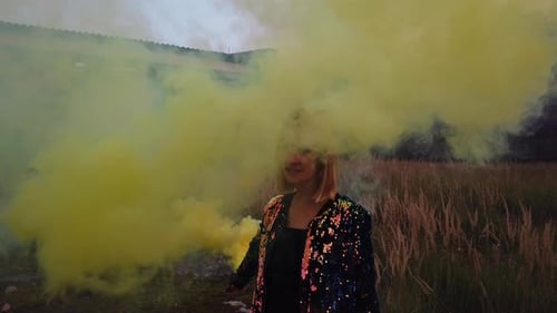 Perfect slow motion cinematic shot of a blonde with a yellow smoke bomb at the airfield
Colorful fog