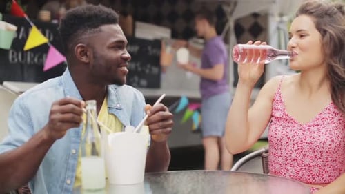 Friends Enjoying Food Truck Meal Together Outdoors
