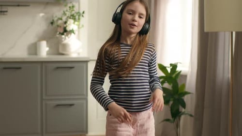 Funny Caucasian Girl Daughter Child Kid in Headphones Listening Music Active Fast Dancing Dancer