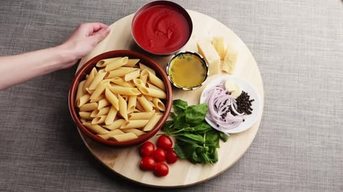 Buntes Muster aus italienischer Pasta, Tomatensauce, Penne-Nudelzutaten, Olivenöl, Gewürzen und Basilikum