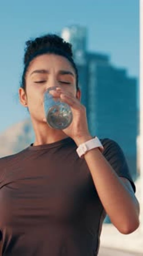 Woman Drinks Water After Workout in the City