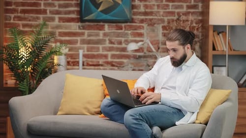 Young Adult Typing on Laptop at Home
