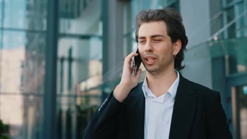 Caucasian Businessman Standing in Office Centre Wearing Formal Suit Talking on the Phone with