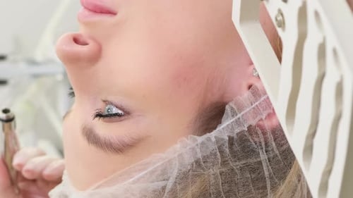 A Dermatologist Examines the Skin on a Young Woman's Face A Beautician at Work in His Office