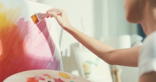 Asia Female use brush painting on canvas create artwork in cozy workshop at home.