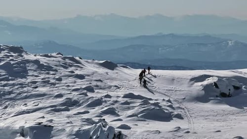 Ski Touring Mountaineers Ascending a Snowy Mountain Ridge