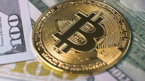 Close Up of Metal Shiny Bitcoin Crypto Currency Coin on US Dollar Bills