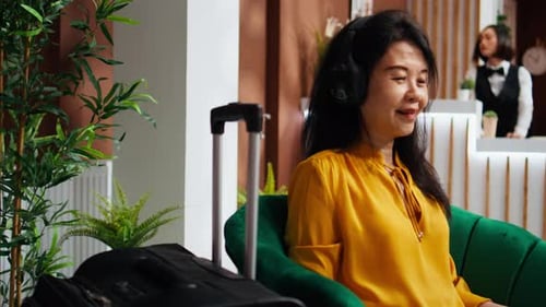 Hotel Guest Using Laptop with Headset in Lounge Area