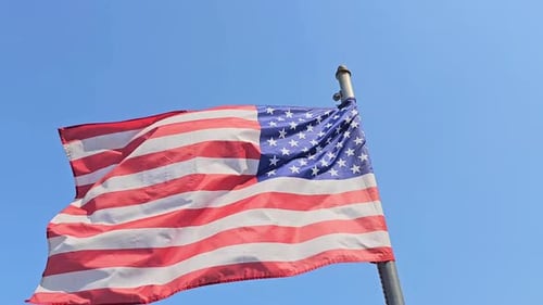 Die Flaggenstreifen der Sterne der USA leuchten hell und wehen im Wind