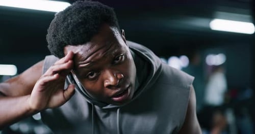 Fatigue, sweating and face of black man in gym for intense workout, cardio challenge and burnout