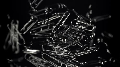 Paper Clips Pile Up on a Dark Surface