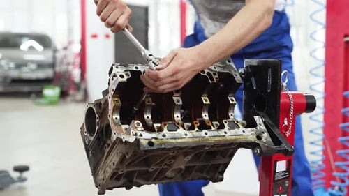 Auto Mechanic Disassembles Car Engine at Modern Workshop Professional Detaches Components Inspecting
