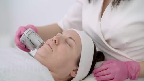 Middle Aged Woman Experiencing Laser Face Lift Treatment on Her Face in a Cosmetology Clinic