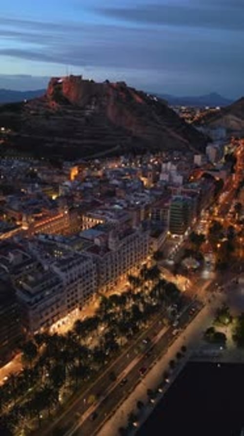 Aerial drone view of the Santa Barbara Castle on the coast of Alicante, Spain at sunset. Vertical