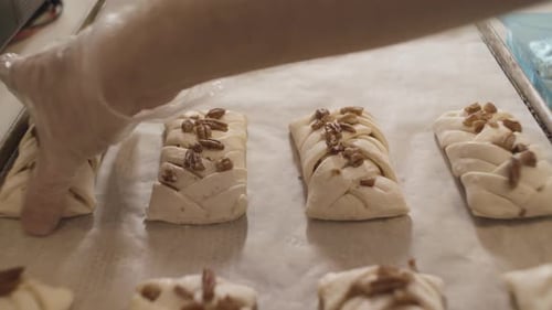 Baker Arranging Pecan Pastries on Baking Sheet