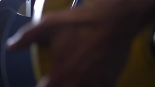 Hand Adding Bright Yellow Weight Plate to Barbell