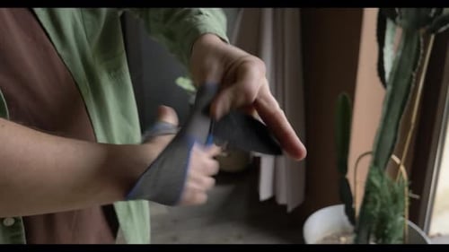 Man Puts on Gray Wrist Support Brace