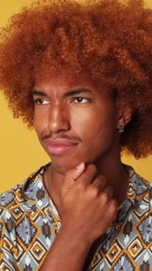 Thoughtful guy, thinking over an idea, choosing, isolated on yellow background in studio