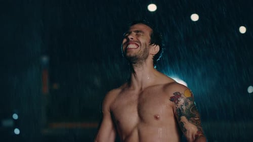 Athletic Man Enjoying Rain at Night