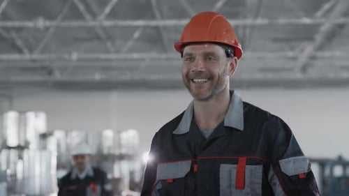 Factory Workers in Hard Hats Shaking Hands