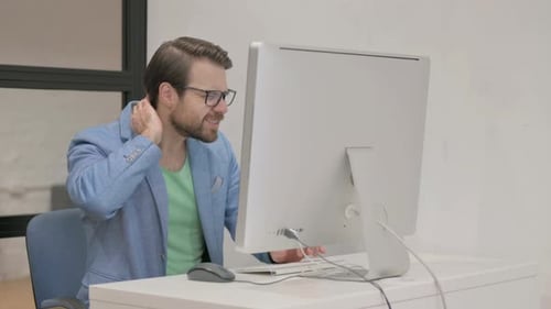 Man at Computer Experiences Neck Pain