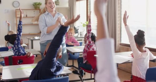 In school, students raising hands in classroom, actively participating in lesson