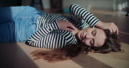 Woman Lying on Floor in Sunlight at Home