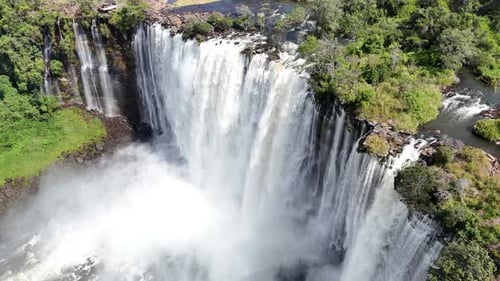 Majestic Tropical Waterfall Cascading Through Lush Green Rainforest Aerial View