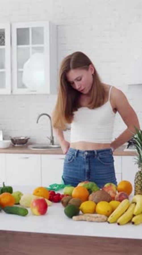 Young Woman Measuring Waist with Fruits and Vegetables