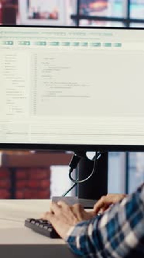 Man in Home Office Looking at Green Screen Tablet and Computer Typing Code