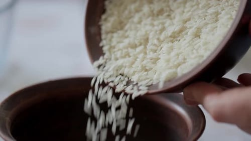 Pouring Rice into Bowl in Kitchen