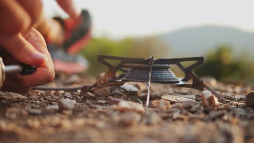 Person Lights Camping Stove in Golden Hour Light