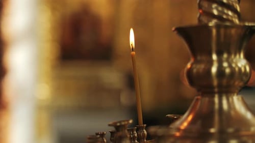 Burning Candle in Church Candle Holder