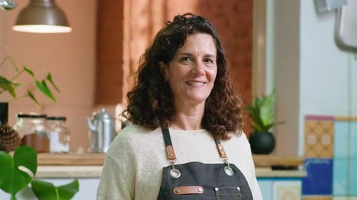 Woman Smiling and Wearing an Apron Indoors