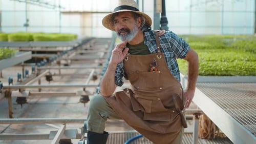 Smiling Farmer Posing in a Greenhouse