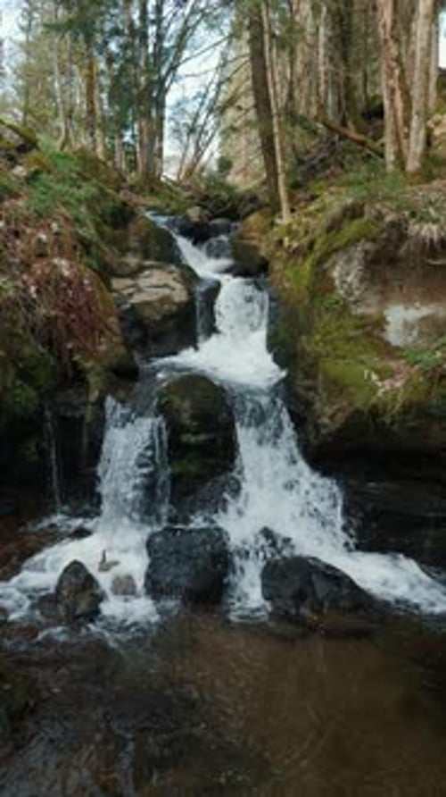 Huge mountain waterfall with cascades and clear water stream. Vertical video