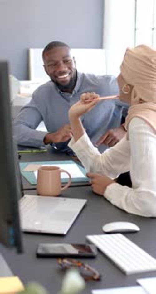 Vertikales Video: Zusammenarbeit im Büro, Kollegen besprechen Projekt mit Laptop und Tablet