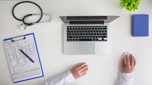 Doctor Typing on Laptop in Clean Workplace