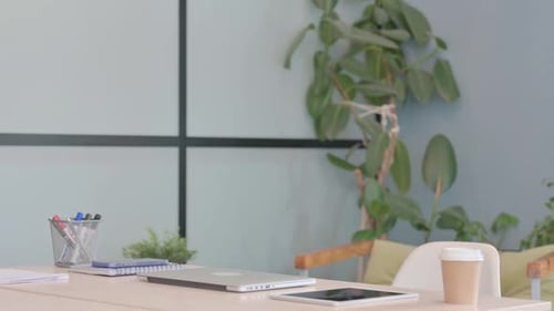 Young Businessman Coming to Office and Starting Work on Laptop