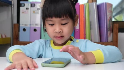 Girl Engaged with a Mobile Phone at Home