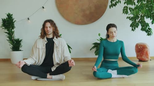 Couple Meditating Together in a Bright Room